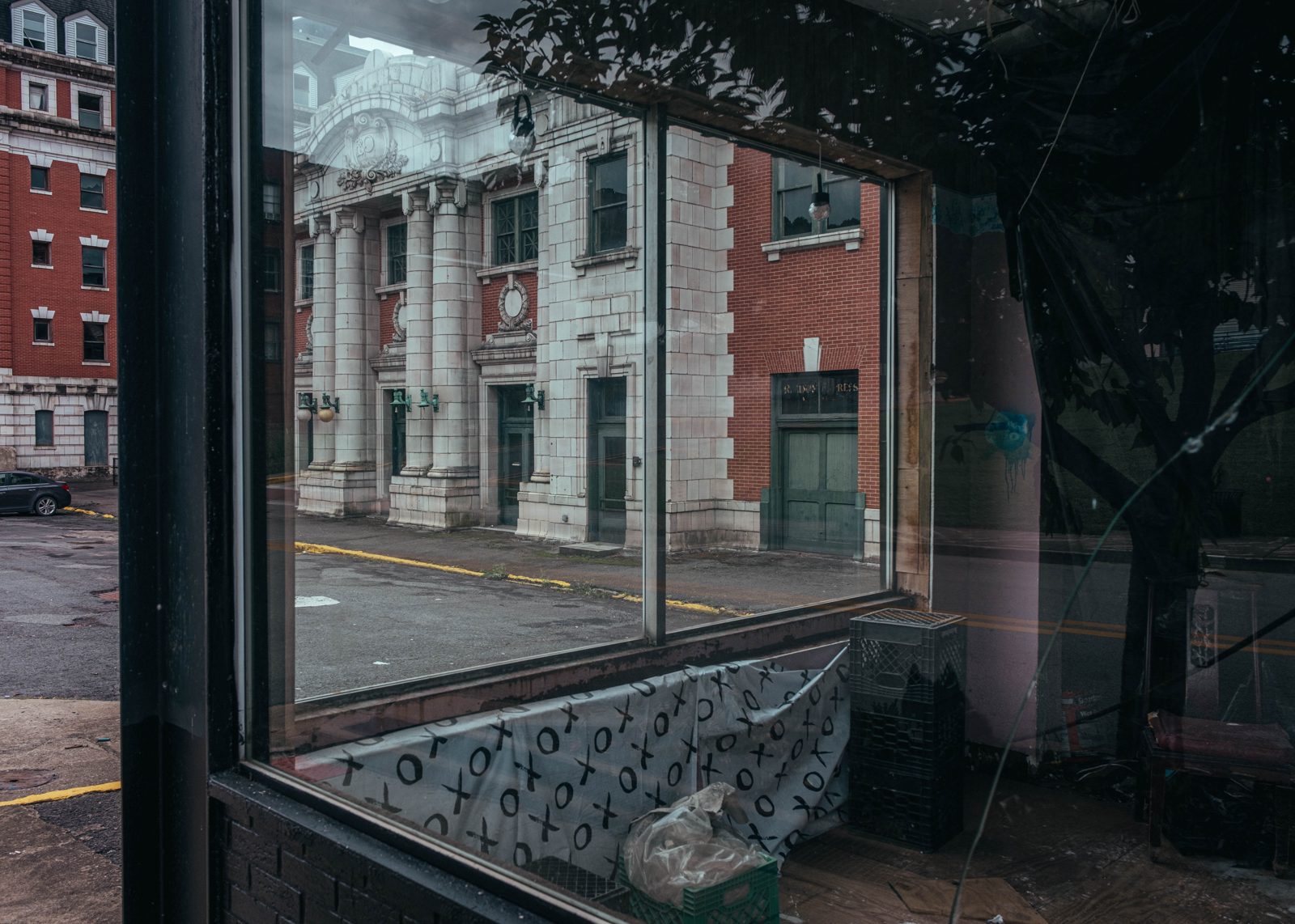 Abandoned hotel viewed through window of abandoned store