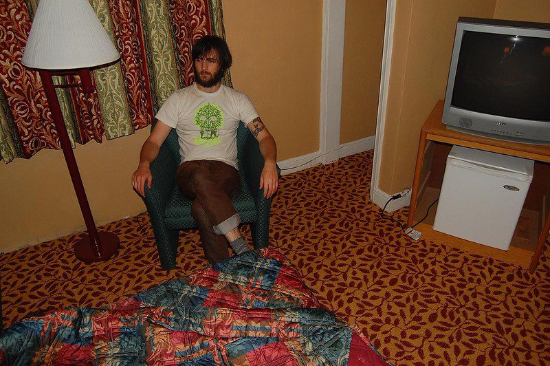 Man in a motel room with a lot of complicated patterns